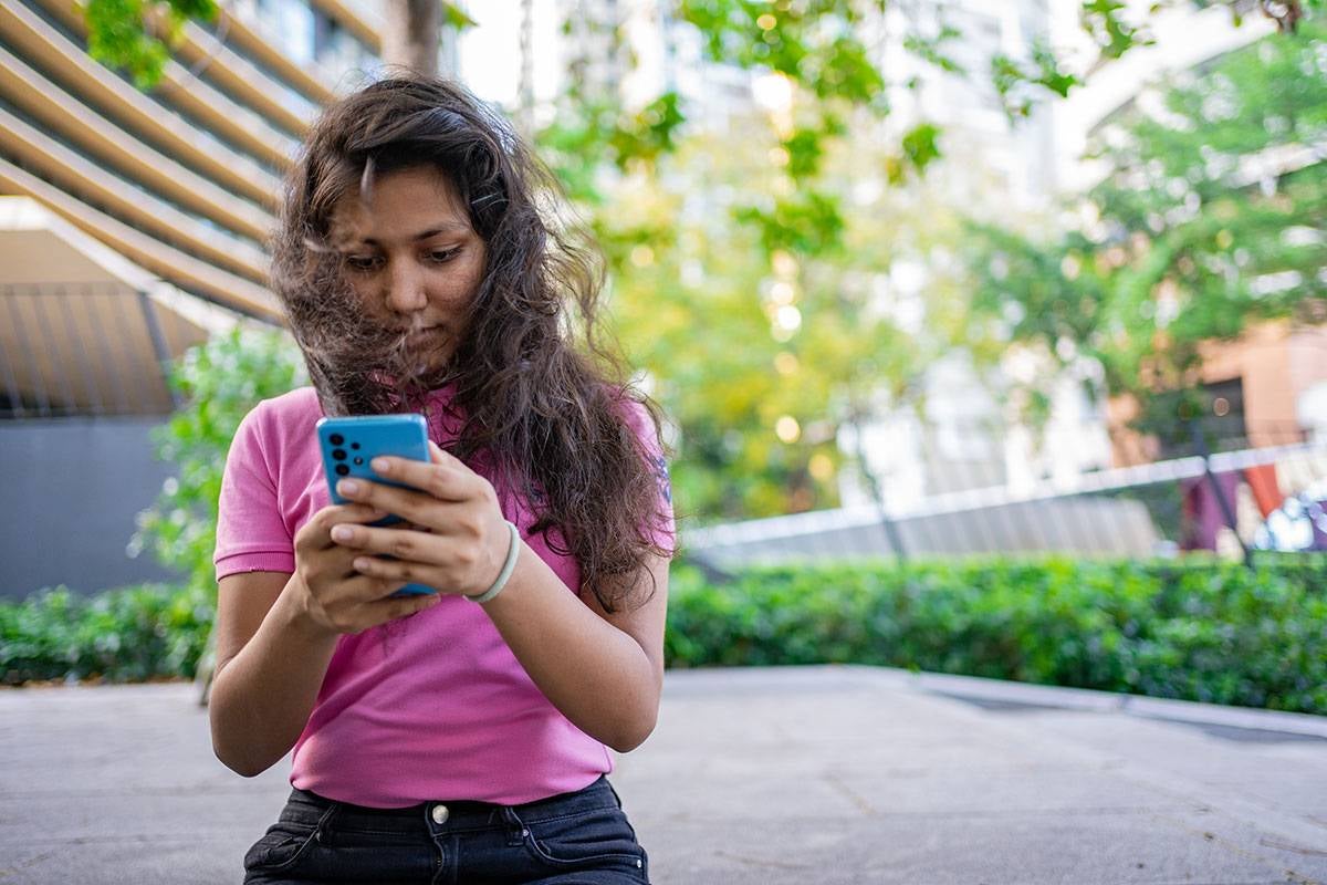 A teenager uses her phone
